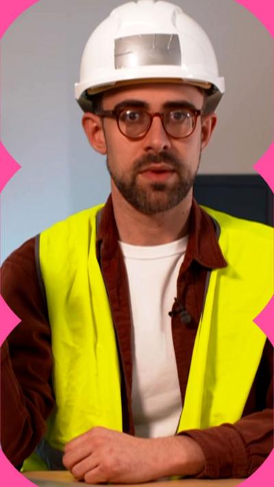Harry Kind wears a white hard hat and a yellow hi-vis vest. He looks directly at the camera with a serious expression.