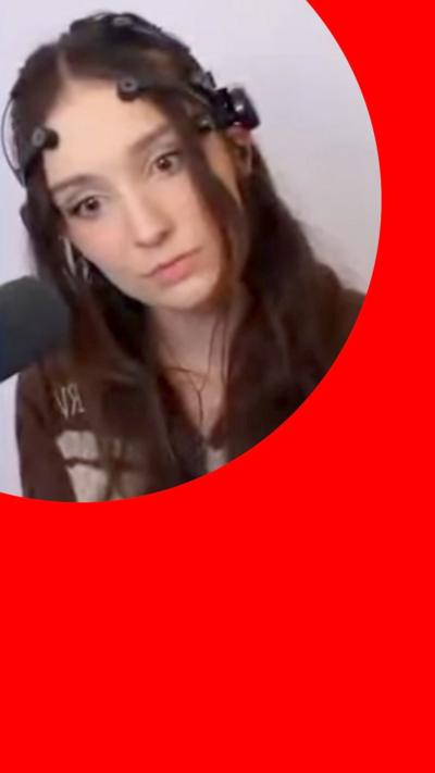 The streamer PerriKaryal sits in a room behind a microphone