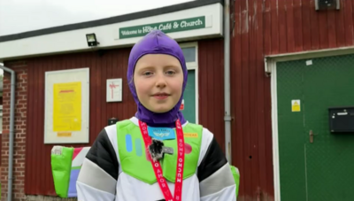 Luna pictured in her buzz lightyear suit. She is looking directly at the cameral and is also wearing a red lanyard around her neck.