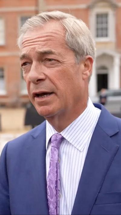 Nigel Farage wearing a purple tie and blue suit jacket.