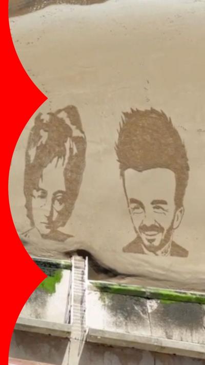 An aerial view of a sandy beach with drawings of John Lennon and David Beckham