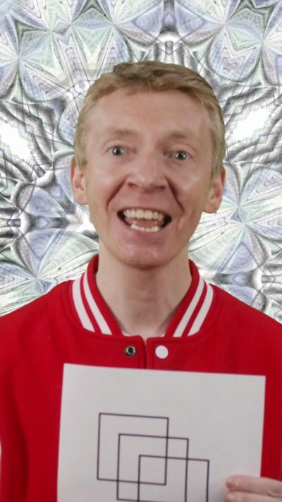 Presenter James Grime holding up a puzzle with three squares on it