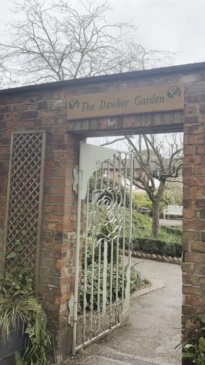 The entrance to the garden, which features a white gate and trellis on the brickwork