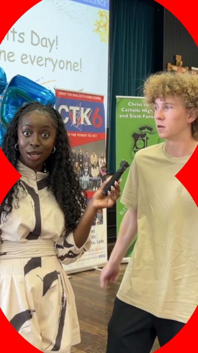 BBC presenter looking shocked and holding a microphone next to a boy