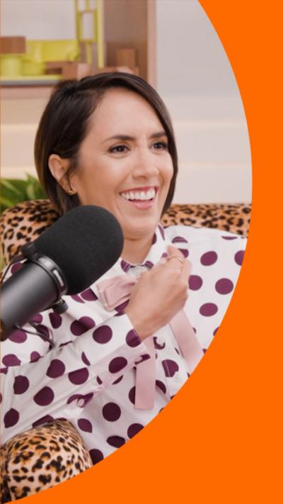 Janette Manrara has short dark hair and is wearing a white top with purple spots and pink trousers.