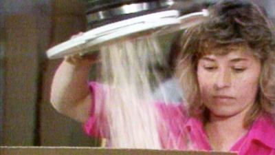 Woman pours popcorn into a box