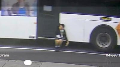 CCTV captures boy dangling off side of a bus