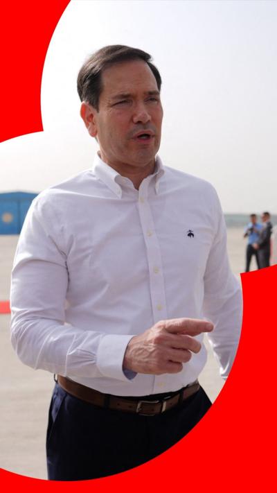 Marco Rubio stood in front of a plane tarmac. 