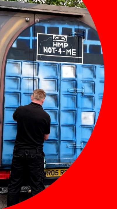 School children stood around a van converted into a 'prison' cell