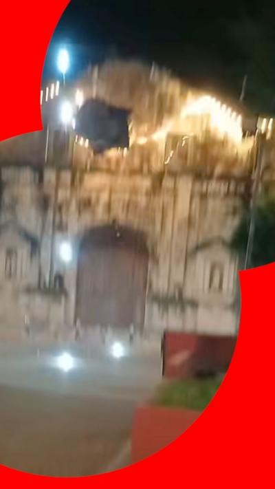 A blurry shot of the front of a church after its bell tower falls to the ground