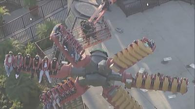 Firefighters helping people stuck on ride. 