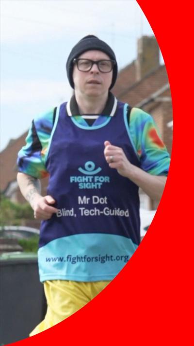 A man in a purple running bib and glasses.