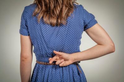 Image of a woman crossing her fingers behind her back