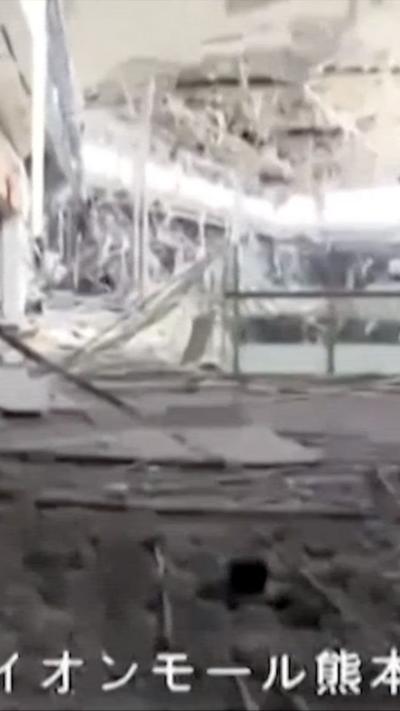A heavily damaged interior of a mall is visible with parts of the roof hanging off and rubble below