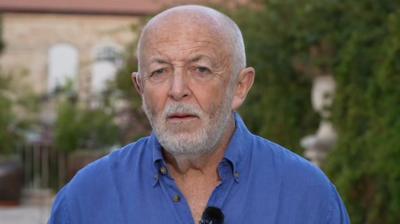 BBC's International Editor, Jeremy Bowen, wearing blue shirt