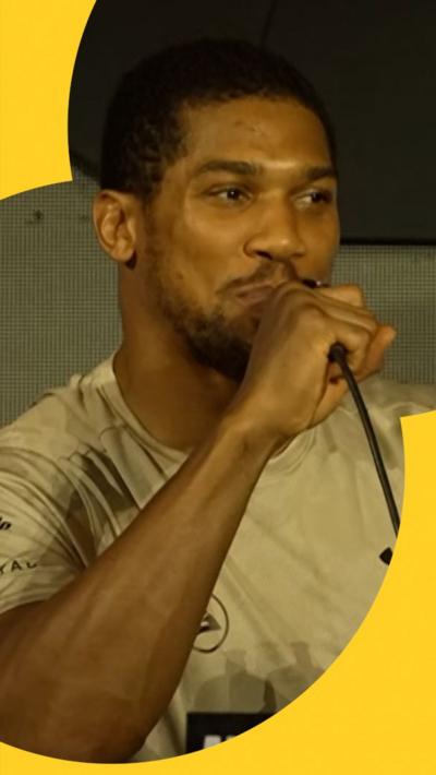 Anthony Joshua holding microphone at press conference