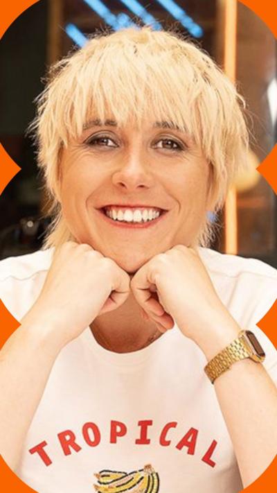 Masie Adam smiles at the camera. She rests her head on her hands and wears a white t-shirt with the words 'topical' on the front.