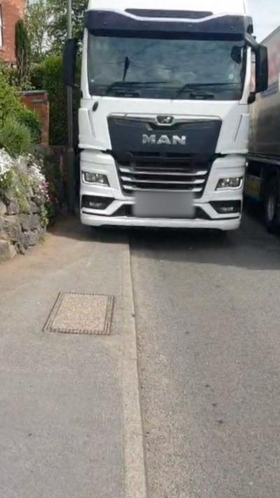 A white HGV mounting a kerb