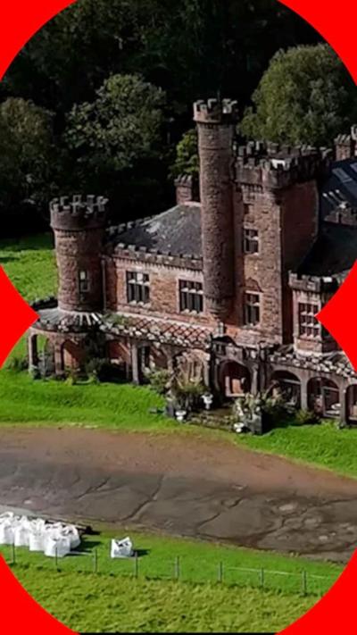 Part of a cast castle with turrets, surrounded by grass.