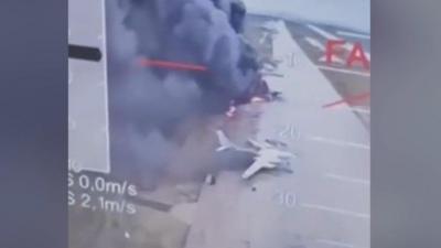 Planes on fire on runway with smoke pluming around them
