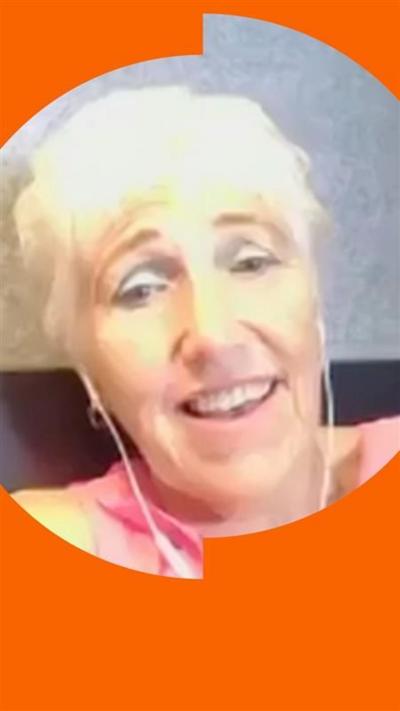 Lucy Bronze's mum looks at the camera, she's wearing in-ear headphones and smiling