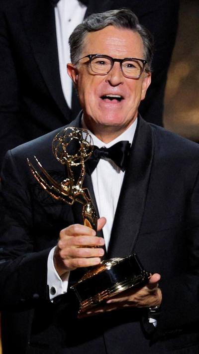Stephen Colbert holds an award