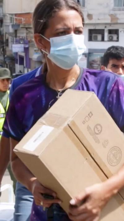 A person in a face mask carrying a box