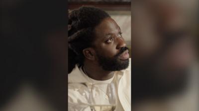 Kwabena looks at the waiter in shock