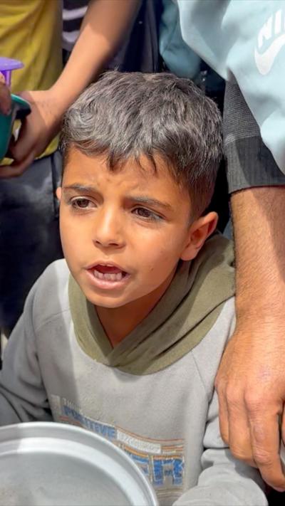 A boy queues for food in Gaza