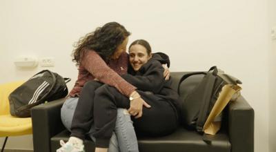 Romi Gonen hugs her mother, Meirav, on a sofa after her release