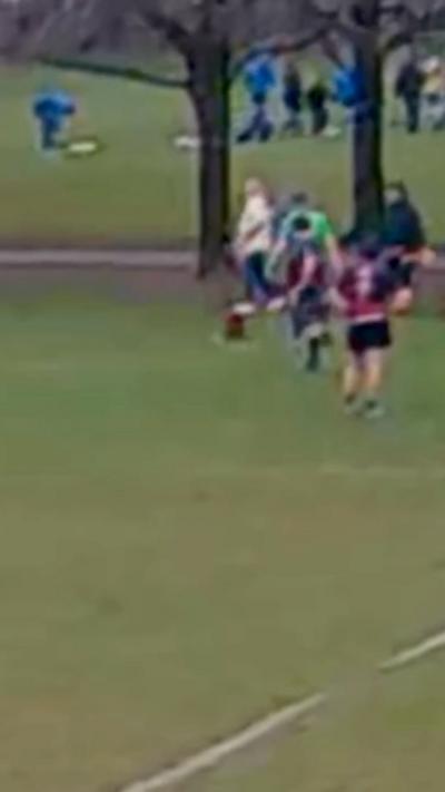 A blurry image of a dog on a rugby pitch