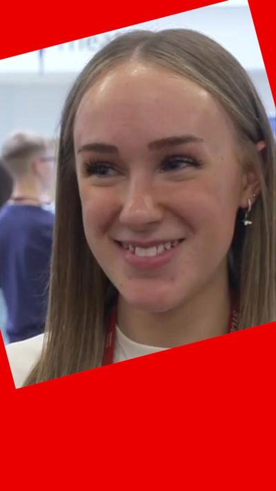 A student smiles. She has long light brown hair