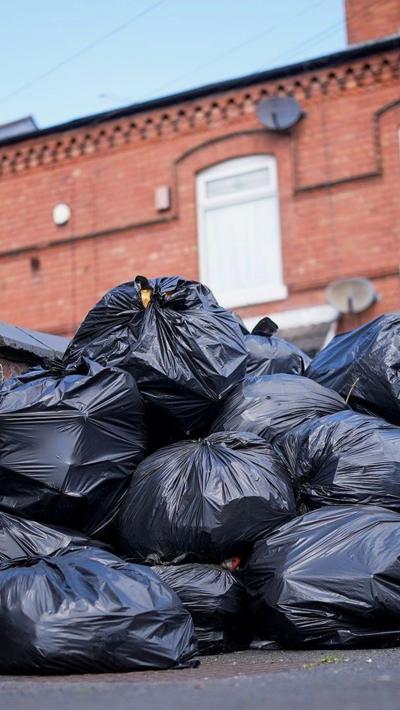 Piles of black bin bags on a street corner