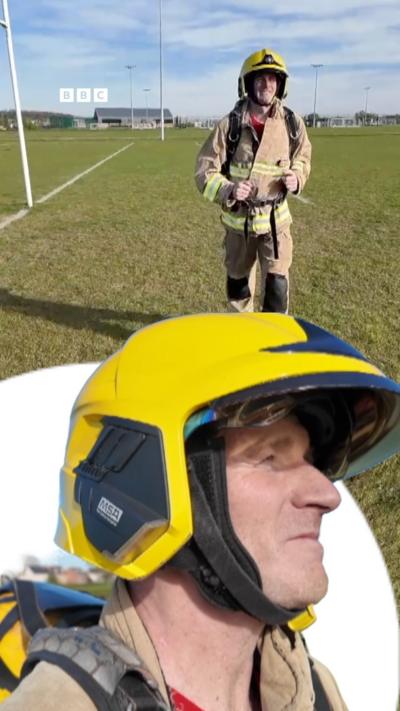 A man wearing a firefighters yellow helmet and uniform.