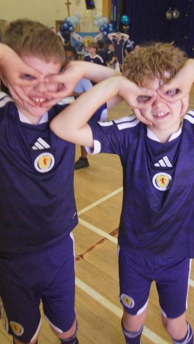 Children in Scotland shirts doing the John McGinn celebration