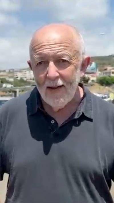 Jeremy Bowen standing outside in the sun wearing a black t-shirt
