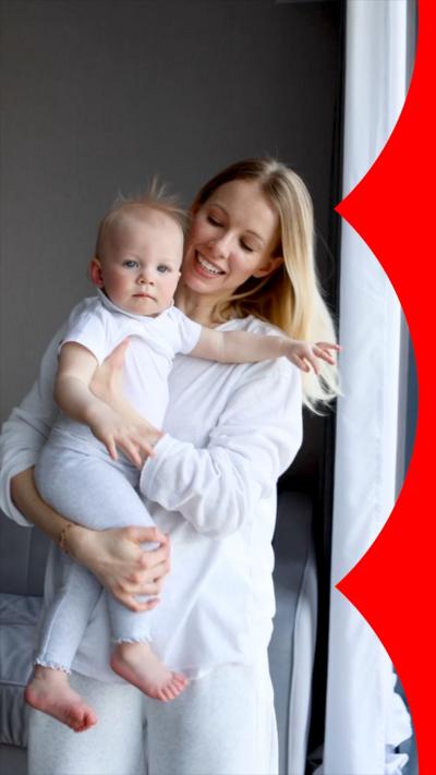 A woman smiles at her baby as she holds them