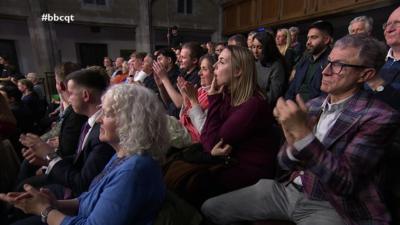 A tiered audience claps