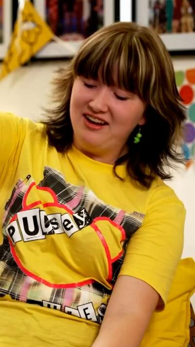 A teenage girl in a yellow Children in Need T-shirt, with shoulder length brown hair.