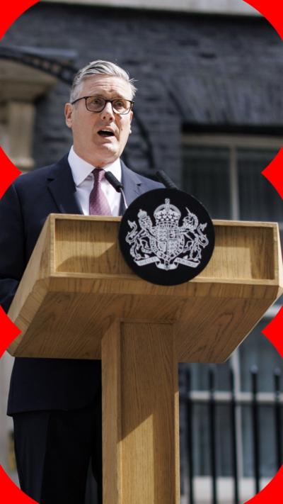 Keir Starmer stands behind a podium
