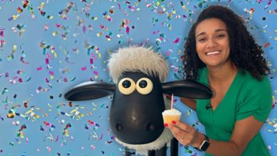 Nina holds a cupcake in front of Shaun the Sheep. The background is blue with confetti