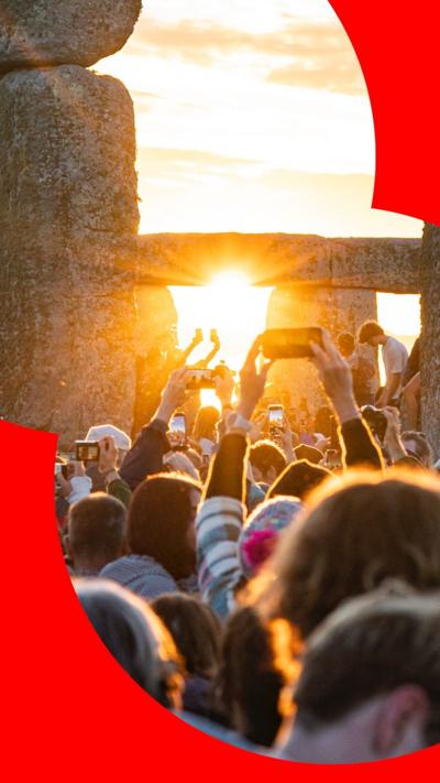 People taking photos of sun rising at Stonehenge