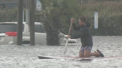 Boy is paddling on a surfboard.