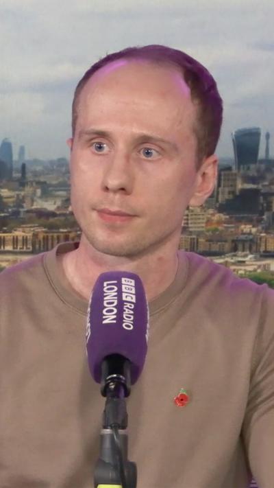 An image with a man sitting in a radio studio behind a microphone.