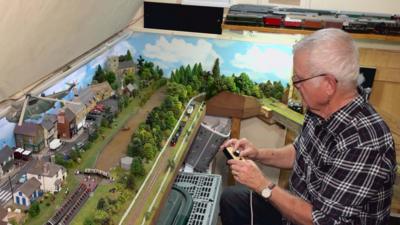 Keith Lodge driving a train around his model railways on a narrowboat