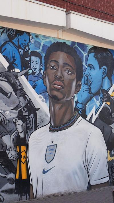 A mural of a black footballer in a white England shirt