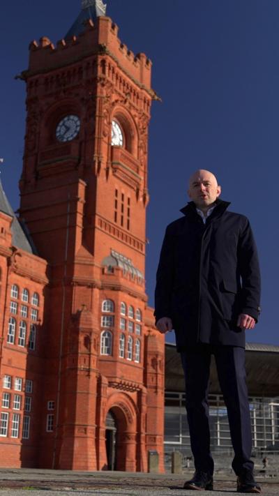 Gareth Lewis standing in front of the Pierhead building in Cardiff Bay