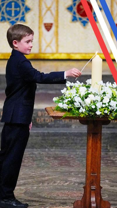 Ten-year-old Alexander Churchill lights a candle while wearing a dark suit