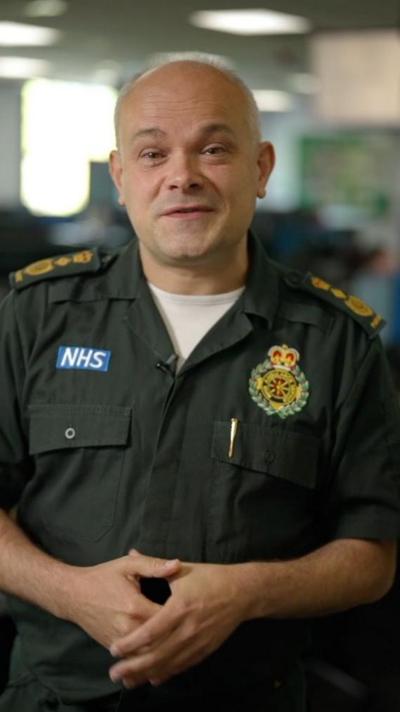 A NHS paramedic speaks to the camera