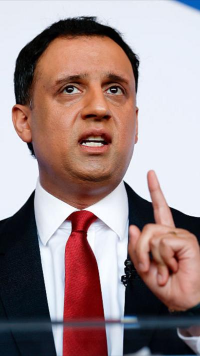 Sarwar speaking, holds his finger up